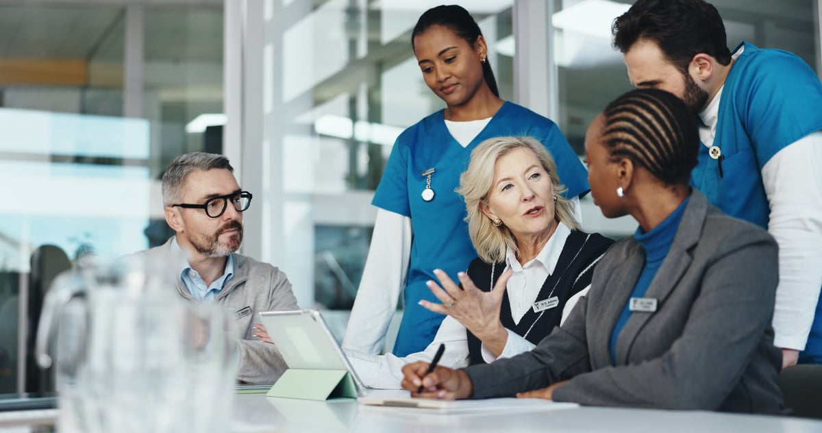 Clinical team planning and reviewing a medical report together in an office